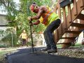 Flattening fresh asphalt on a new walkway installation in Winnipeg