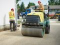 Steamrolling gravel to pack it down prior to paving a new driveway in Winnipeg