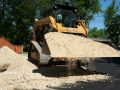 A Superior Asphalt equipment operator moving gravel