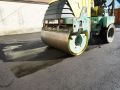 Steamrolling the asphalt to smooth out the new driveway in Winnipeg